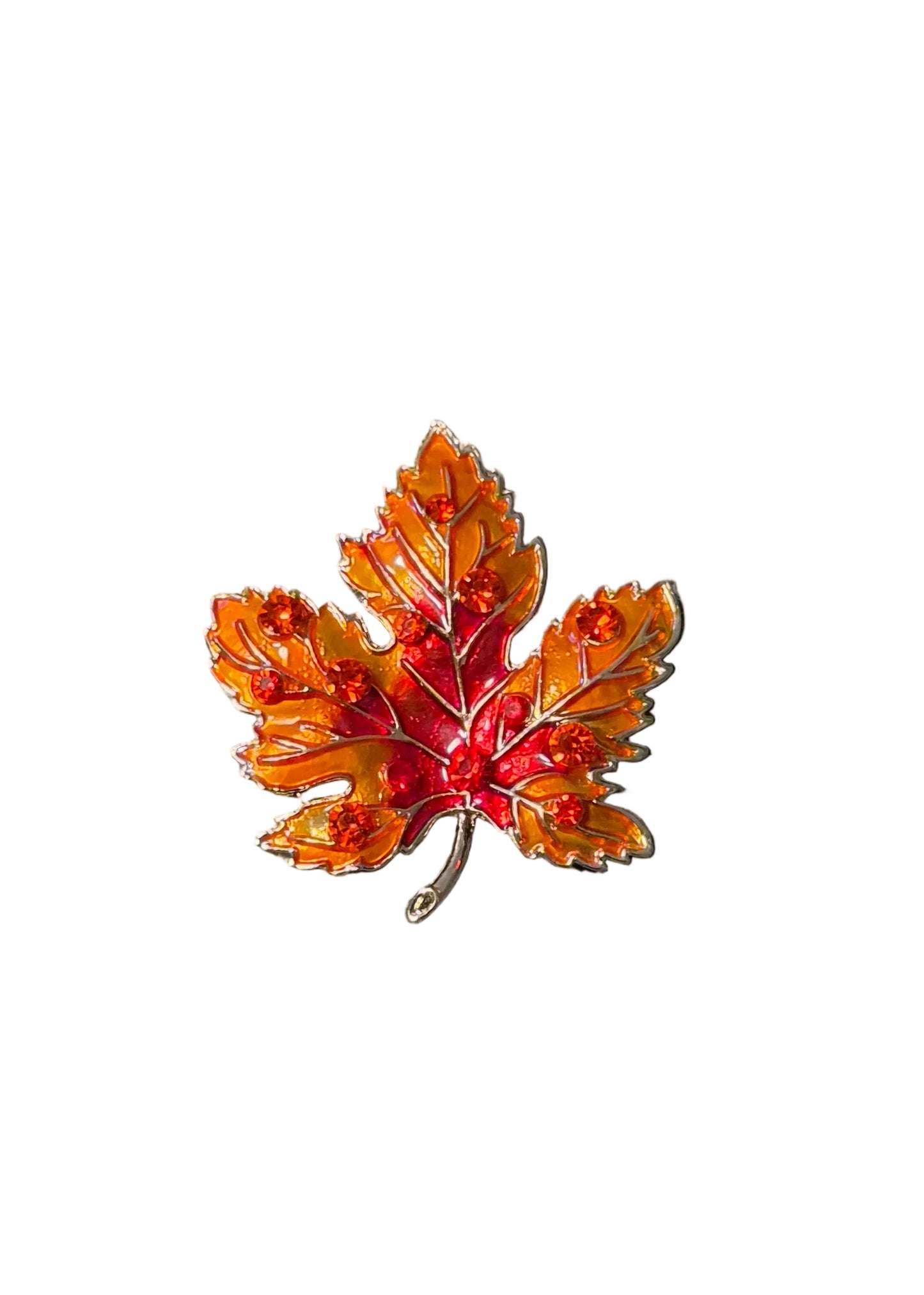 A small enamel maple leaf pin in orange, red, and yellow tones