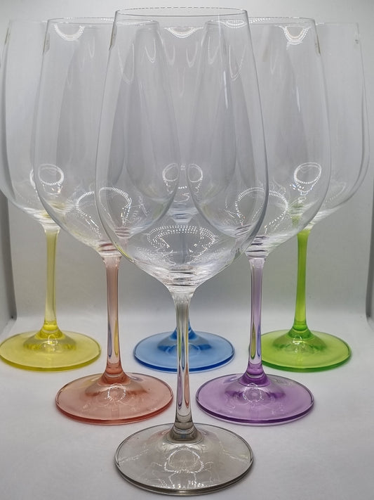 Set of colourful red wine glasses on a white surface