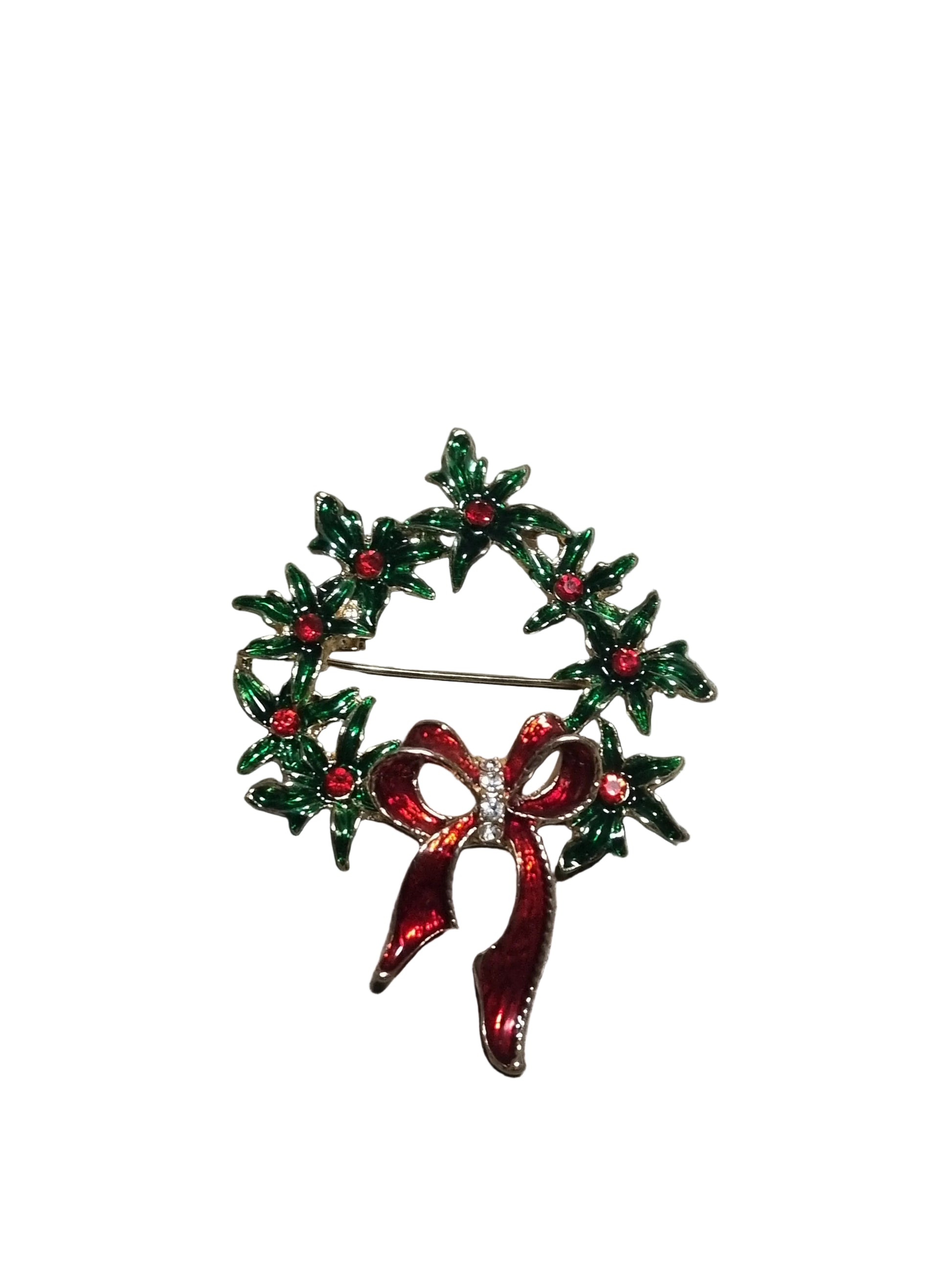 Decorative brooch with green wreath and red bow rface