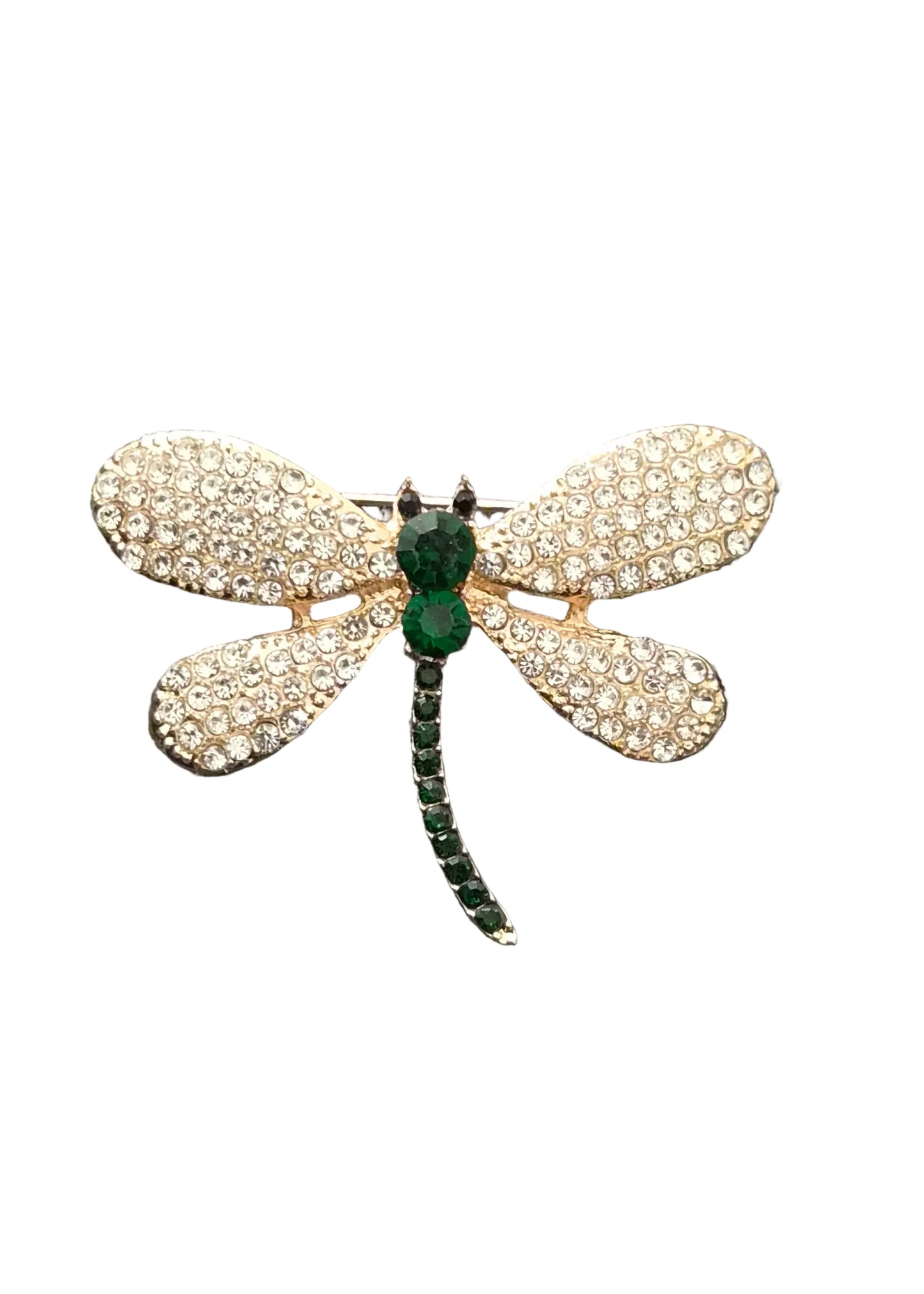 A dragonfly-shaped brooch with pavé-set clear stones on its wings and a green emerald-cut body and segmented green tail.