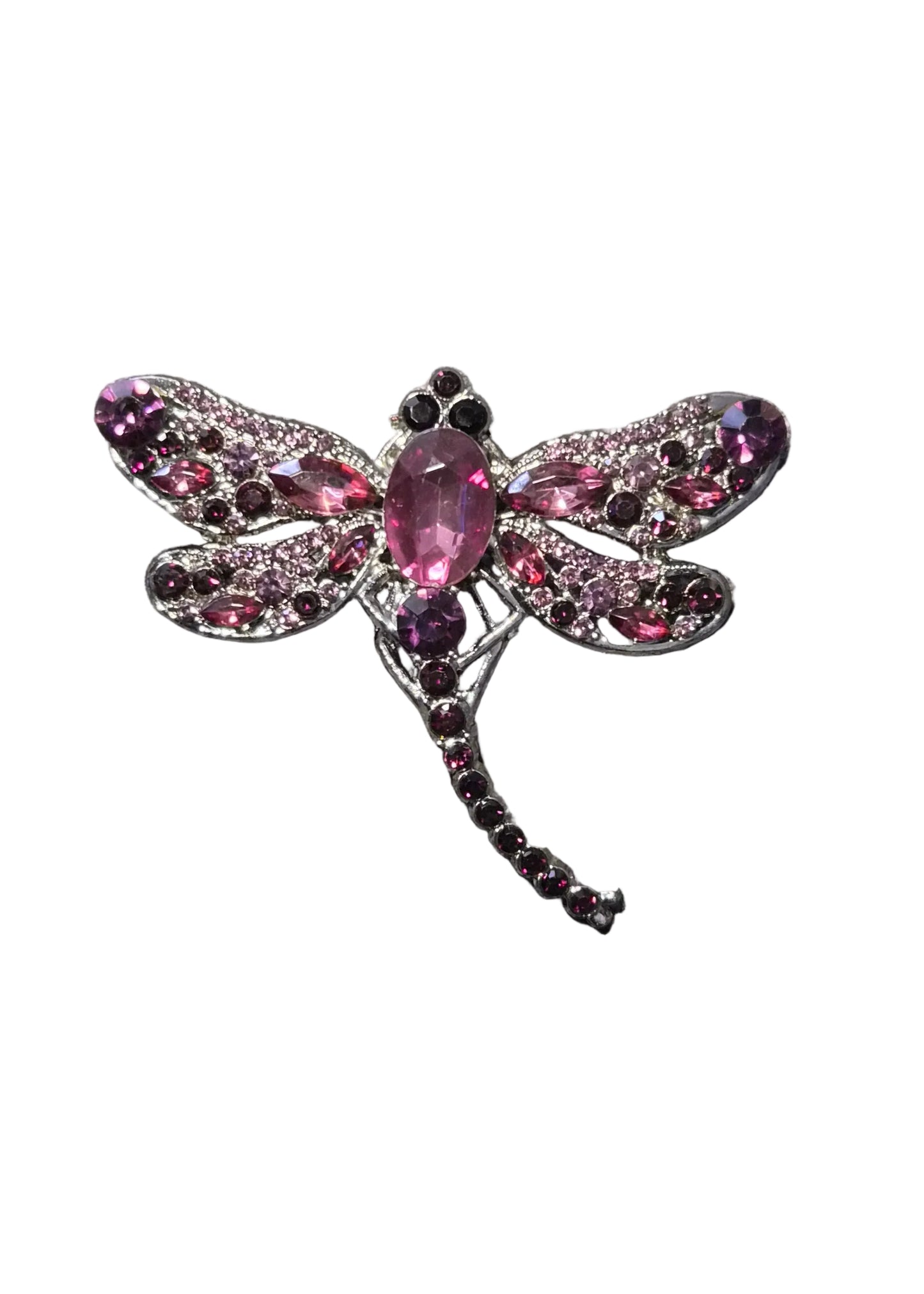 A dragonfly-shaped brooch with pink gemstones and a silver-toned metal setting,.