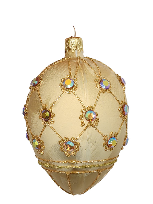 Decorative egg with gold embroidery and colorful stones on a white background