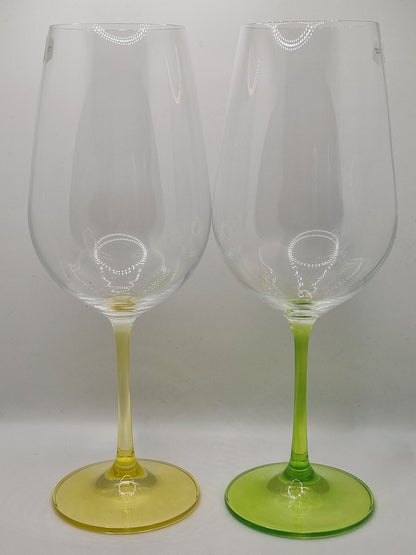 Two red wine glasses with green and yellow stems on a white background