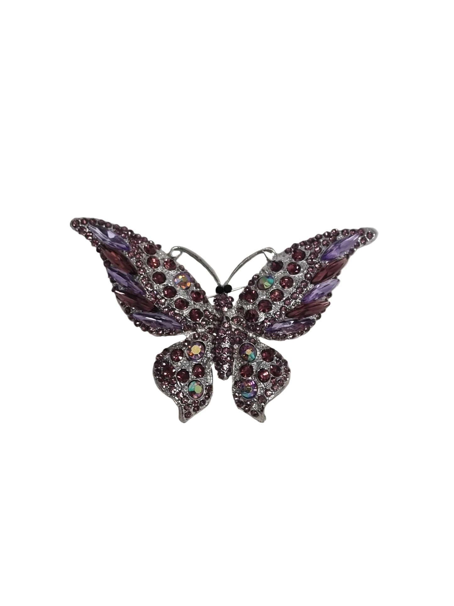 Decorative brooch with purple gemstones on a white fabric background